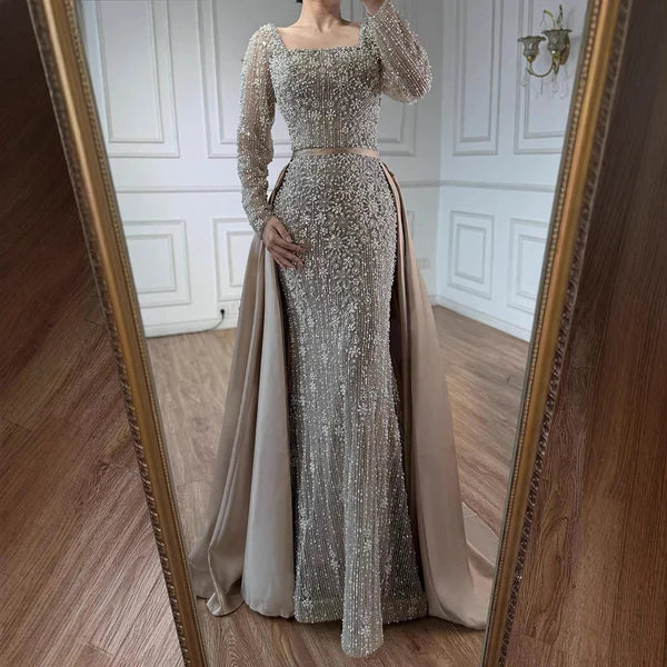 Elegant silver evening gown with long sleeves and a train, reflected in a mirror. Beaded, long train, silk, floor length, formal, dress, 