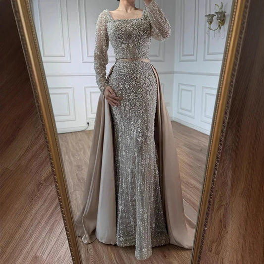 Elegant silver evening gown with long sleeves and a train, reflected in a mirror. Beaded, long train, silk, floor length, formal, dress, 