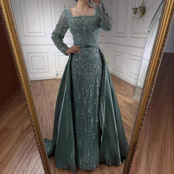 Long, elegant green dress with intricate detailing in front of a mirrorElegant silver evening gown with long sleeves and a train, reflected in a mirror. Beaded, long train, silk, floor length, formal, dress, champagne colour, cream, beige, nude, skin colour, dubai style, middle east, muslim, old-money, classic, luxury, video, sparkle, glitter, real photos, 