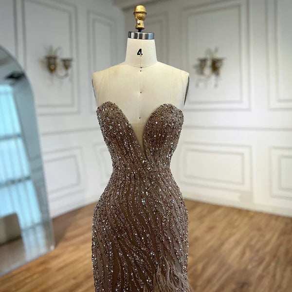 Woman wearing  champagne formal evening gown  dress with a slit intricate beading, beige, cream feathered bottom, evening gown with a high slit, glitter sparkling diamonds, sweetheart neckline  v-neck, mermaid, train, old-money classy elegant dubai style, saudi arabic, sleeveless, elliesaab, prom, wedding guest, bridesmaid, mother of the bride, christmas, luxury, celebrity, expensive cheap, vintage, real photos, high-end, chooseone, viral, where to buy, now, shop, store, miss universe, best, number one top