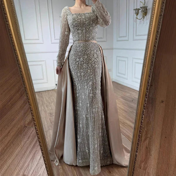 Elegant silver evening gown with long sleeves and a train, reflected in a mirror. Beaded, long train, silk, floor length, formal, dress, 