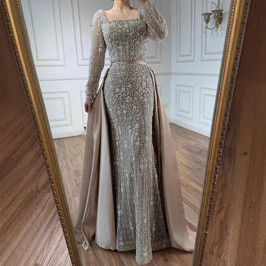 Elegant silver evening gown with long sleeves and a train, reflected in a mirror. Beaded, long train, silk, floor length, formal, dress, 