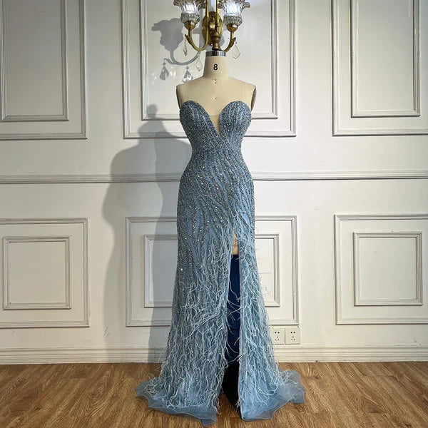 Woman wearing  blue formal evening gown  dress with a slit,intricate beading, powder baby blue, feathered bottom, evening gown with a high slit, glitter sparkling diamonds, sweetheart neckline  v-neck, mermaid, train, old-money classy elegant dubai style, saudi arabic, sleeveless, elliesaab, prom, wedding guest, bridesmaid, mother of the bride, christmas, luxury, celebrity, expensive cheap, vintage, real photos, high-end, chooseone, viral, where to buy, now, shop, store, miss universe, best, number one top