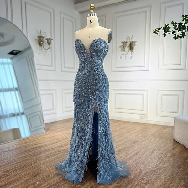 Woman wearing  blue formal evening gown  dress with a slit,intricate beading, powder baby blue, feathered bottom, evening gown with a high slit, glitter sparkling diamonds, sweetheart neckline  v-neck, mermaid, train, old-money classy elegant dubai style, saudi arabic, sleeveless, elliesaab, prom, wedding guest, bridesmaid, mother of the bride, christmas, luxury, celebrity, expensive cheap, vintage, real photos, high-end, chooseone, viral, where to buy, now, shop, store, miss universe, best, number one top