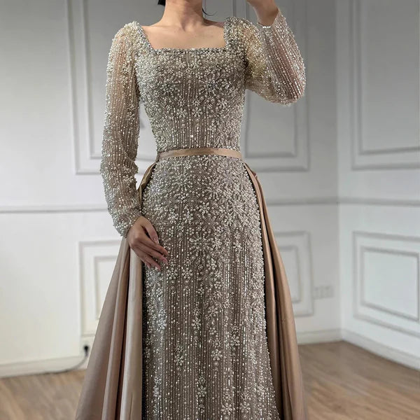 Elegant silver evening gown with long sleeves and a train, reflected in a mirror. Beaded, long train, silk, floor length, formal, dress, champagne colour, cream, beige, nude, skin colour, dubai style, middle east, muslim, old-money, classic,
