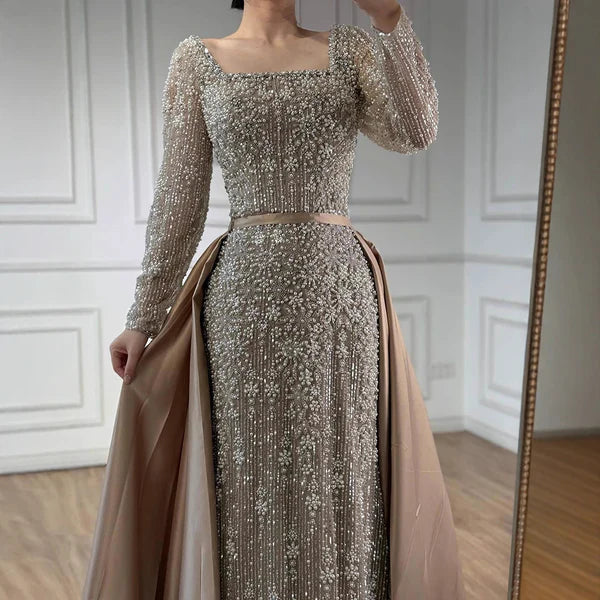 Elegant silver evening gown with long sleeves and a train, reflected in a mirror. Beaded, long train, silk, floor length, formal, dress, champagne colour, cream, beige, nude, skin colour, dubai style, middle east, muslim, old-money, classic, luxury, 