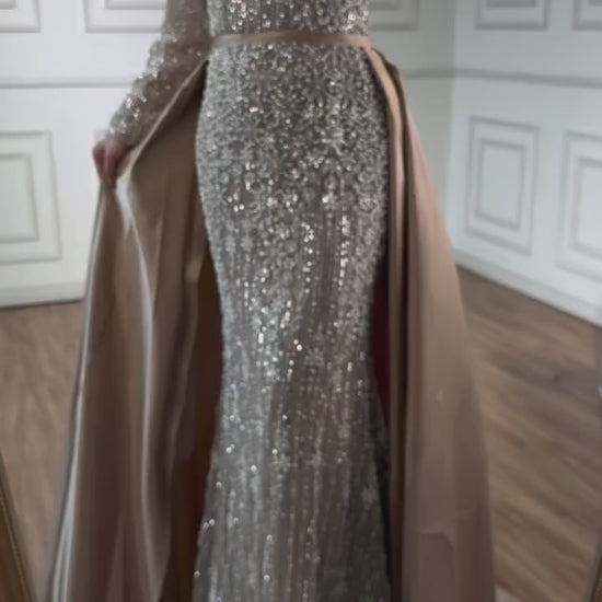 Elegant silver evening gown with long sleeves and a train, reflected in a mirror. Beaded, long train, silk, floor length, formal, dress, champagne colour, cream, beige, nude, skin colour, dubai style, middle east, muslim, old-money, classic, luxury, video, sparkle, glitter