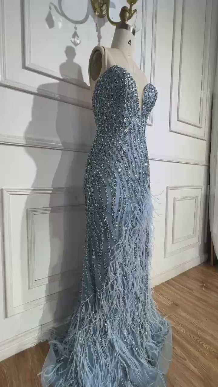 Woman wearing  blue formal evening gown  dress with a slit,intricate beading, powder baby blue, feathered bottom, evening gown with a high slit, glitter sparkling diamonds, sweetheart neckline  v-neck, mermaid, train, old-money classy elegant dubai style, saudi arabic, sleeveless, elliesaab, prom, wedding guest, bridesmaid, mother of the bride, christmas, luxury, celebrity, expensive cheap, vintage, real photos, high-end, chooseone, viral, where to buy, now, shop, store, miss universe, best, number one top